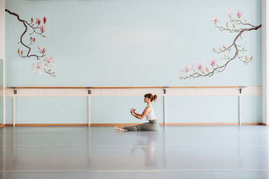 Ballerina exercising on floor in studio