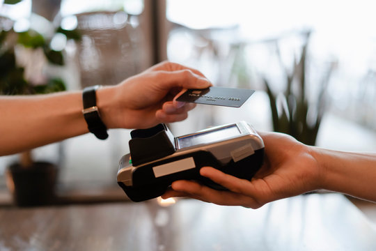 Man with protective mask paying with credit card in restaurant