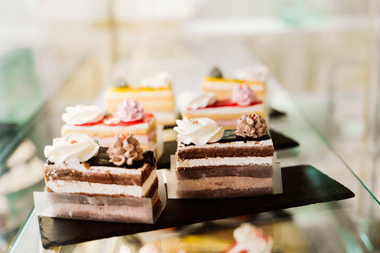 Pastries on plates at glass counter in bakery