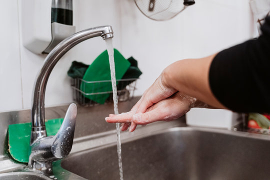 Female baker washing hands at bakery