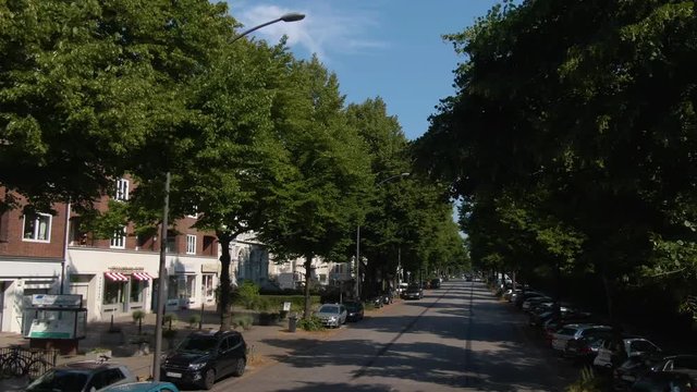 Flying trough the streets of Hamburg a city in Germany. On Top of a double Decker bus on a sunny day in summer. Residential area.
