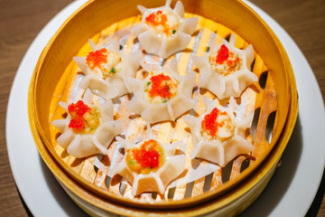 Chinese snacks. chinese yellow steamed dumpling. Chinese Traditional cuisine concept. Dumplings Dim Sum in bamboo steamer