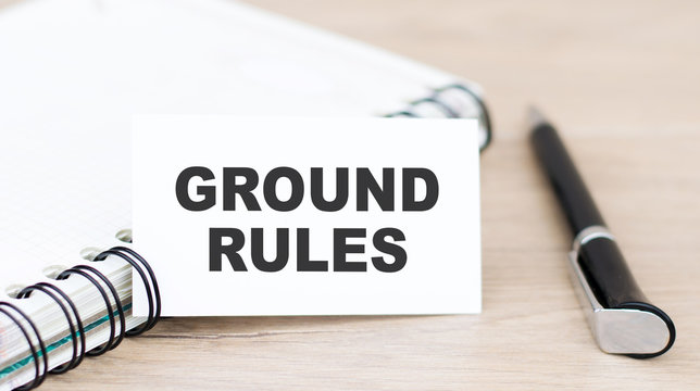 a card with text ground rules on the table next to the notebook