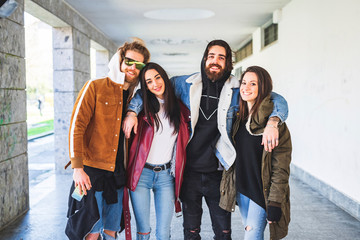 Happy male and female friends wearing warm clothing standing indoors