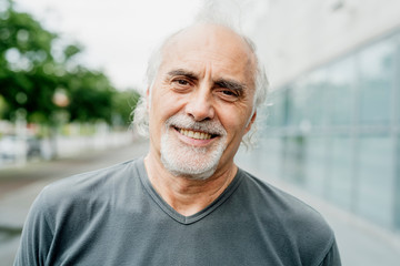 Close-up of smiling senior man in city