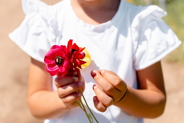 Little girl with a handful of bright flowers
