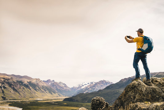Mature man photographing mountains with smart phone against sky, Patagonia, Argentina
