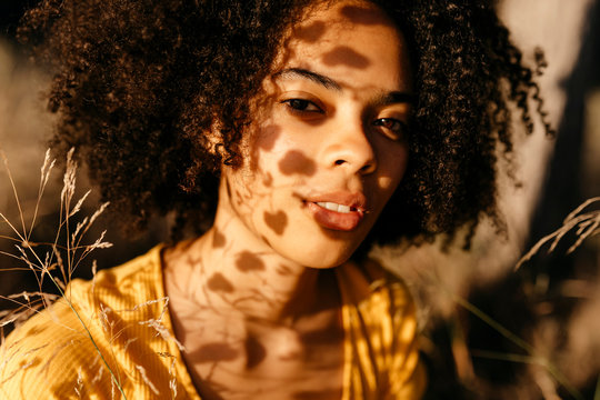 Close-up of beautiful woman with afro hair in forest