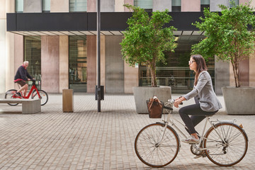 Businesswoman commuting on bicycle in city