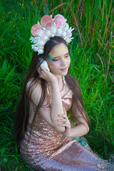 the little mermaid listens to the sound of a shell