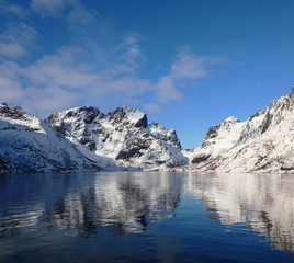 Fototapeta na wymiar Beautiful reflection of winter mountains in Olenilsoya in Reine, Lofoten Islands, Norway