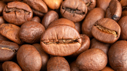 Roasted Coffee beans background close up. International coffee day concept. Macro photography. Texture for design.
