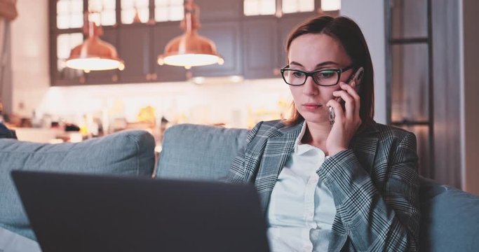 Young Business Woman Working From Home, Dog Interrupts. SLOW MOTION. Conference call on laptop. Female learning online. Puppy playing with work papers. Mess in a room. Entrepreneur Work life balance. 