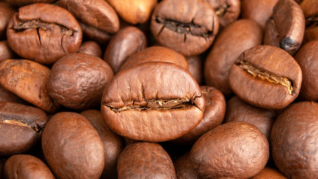 Roasted Coffee beans background close up. International coffee day concept. Macro photography. Texture for design. © alia.kurianova