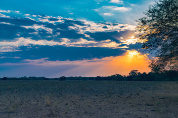 atardecer de campo sin vegetación con el cielo azul y amarillo