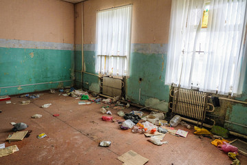 Room of an old abandoned building filled with trash on the floor
