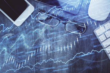 Multi exposure of forex graph hologram over desktop with phone. Top view. Mobile trade platform concept.