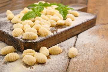 Fototapeta na wymiar Gnocchi with potatoes. Traditional italian food from Rome, Sardinia, south of italy. Homemade gnocchi with parmesan, egg, cornmeal (semolina). On a wooden table. High quality photo. Above. Copy space 