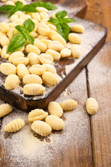 Fototapeta na wymiar Gnocchi with potatoes. Traditional italian food from Rome, Sardinia, south of italy. Homemade gnocchi with parmesan, egg, cornmeal (semolina). On a wooden table. High quality photo. Copy space 