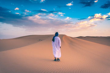 Fototapeta na wymiar Berber man wearing traditional tuareg clothes in the Sahara Desert at dawn, Merzouga, Morocco
