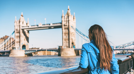 London tourist on Europe travel woman walking on city street looking at Tower Bridge landmark. Famous european destination vacation enjoying spring in England, Great Britain, UK.