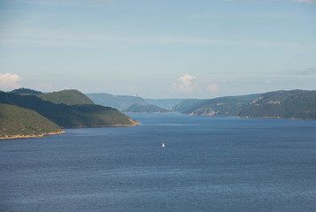 A sailboat is shown on the Saguenay Fjord in the Saguenay region of Quebec Canada
