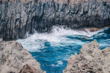 Turquoise blue wave of the Atlantic Ocean wave on broken cliff rock in the geological Alagoa da Fajazinha, Terceira - Azores PORTUGAL