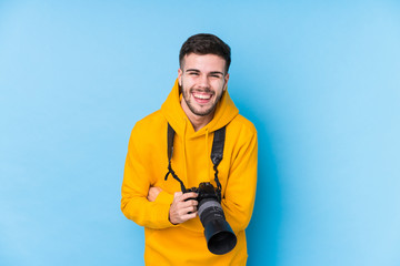Young caucasian photographer man isolated laughing and having fun.
