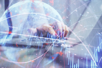 Obraz premium Double exposure of businesswoman hands typing on computer and financial graph hologram drawing. Stock market analysis concept.