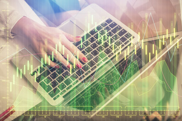 Double exposure of woman hands typing on computer and financial graph hologram drawing. Stock market analysis concept.