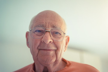 Portrait of older senior man in orange shirt in natural light