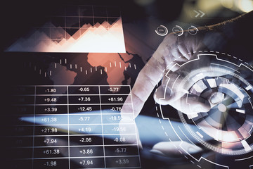 Double exposure of man's hands holding and using a digital device and forex graph drawing. Financial market concept.