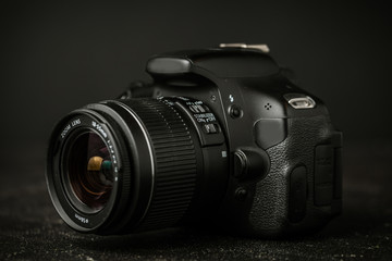 Digital camera with a detachable lens. DSLR on the black background