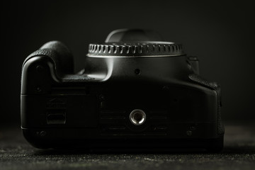 Fototapeta premium Bottom view of photo camera body on the black background. Tripod mount