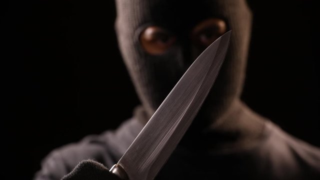 The Criminal hold the knife in hand.