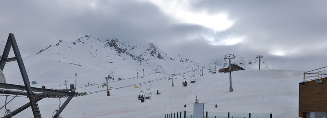 Panoramic landscape of Las Leñas ski resort, with ski lifts in the foreground and clouds in the background