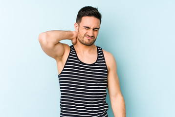 Young caucasian man isolated on blue background having a neck pain due to stress, massaging and touching it with hand.