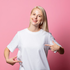 Blonde woman in white moch-up tshirt on pink background