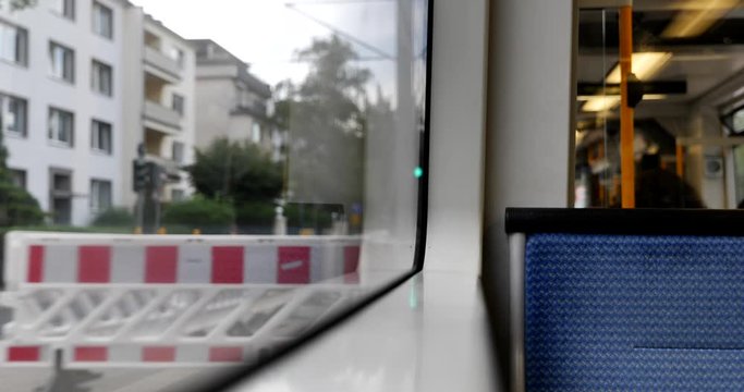 Selected focus view at blue seat on the moving Light rail tram with street view of residential district in Düsseldorf, Germany through window. Enjoy moment during commute and travel by Tram in Europe.