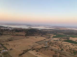 Hot air balloon flight at sunrise, Aerial View over the great Alqueva lake, in Alentejo, Portugal