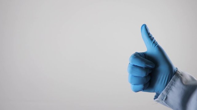 Mano con guante medico dando se&ntilde;al de aprobacion