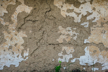 The old cracked adobe wall of the abandoned house, background texture image.