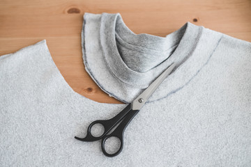 upcycling old clothes concept, sweatshirt with scissors to cut a new neckline