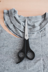 upcycling old clothes concept, t-shirt with scissors to cut a new neckline