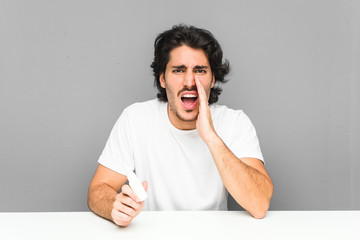 Young man holding a spray nasal shouting excited to front.