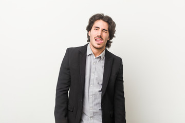 Young business man against a white background funny and friendly sticking out tongue.