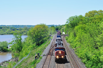 An image of an oncoming CN freight train on the Canadian Railway going through Ontario, Canada carrying various containers, tanks and cargoes.