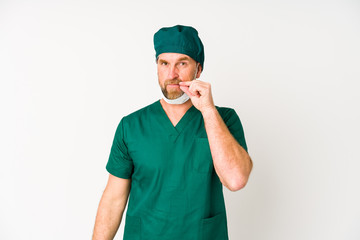 Surgeon senior man isolated on white background with fingers on lips keeping a secret.