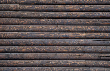 Wooden wall assembled of beams or logs. Dark brown log wall