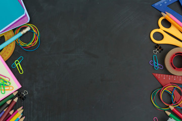 Top view of school supplies on chalkboard with copy space. For background use. Back to school concept